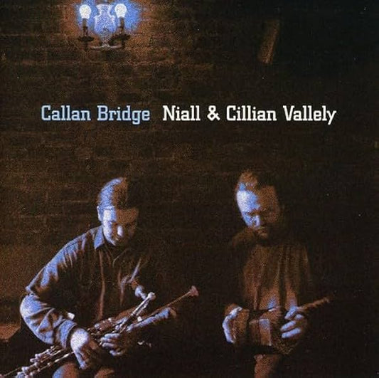Two musicians playing instruments with a dark brick wall background and text overlay.