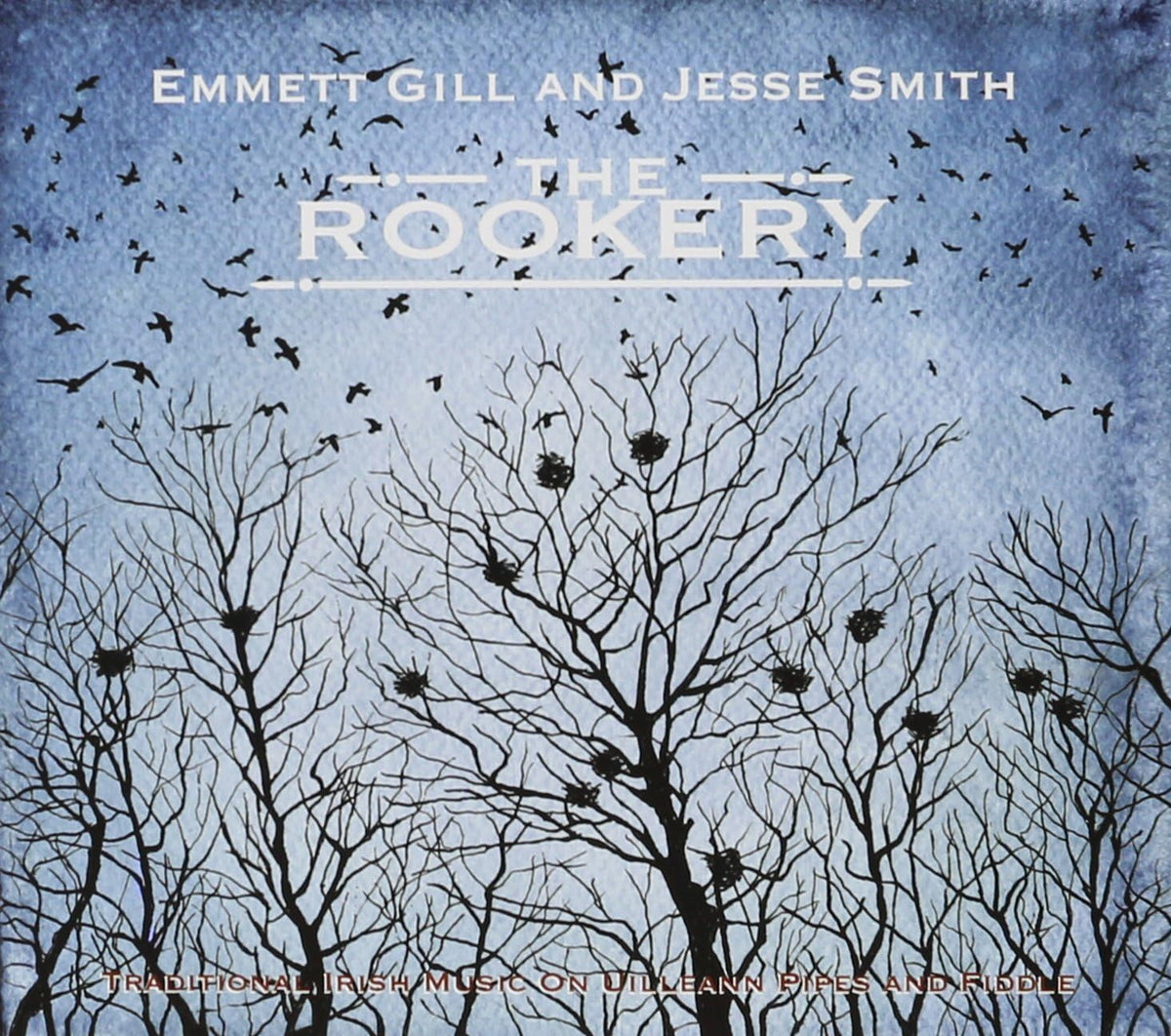 Crows fly in a dark sky over the silhouette of trees stripped of leaves