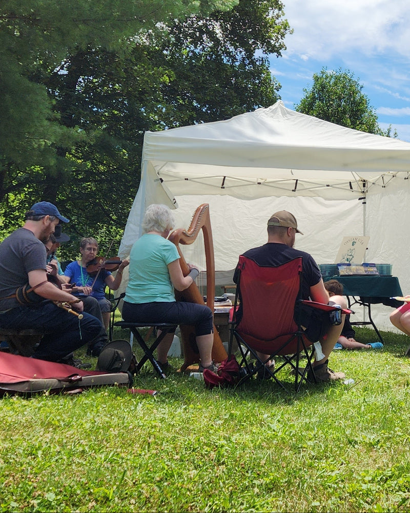 Musicians sit around a tent